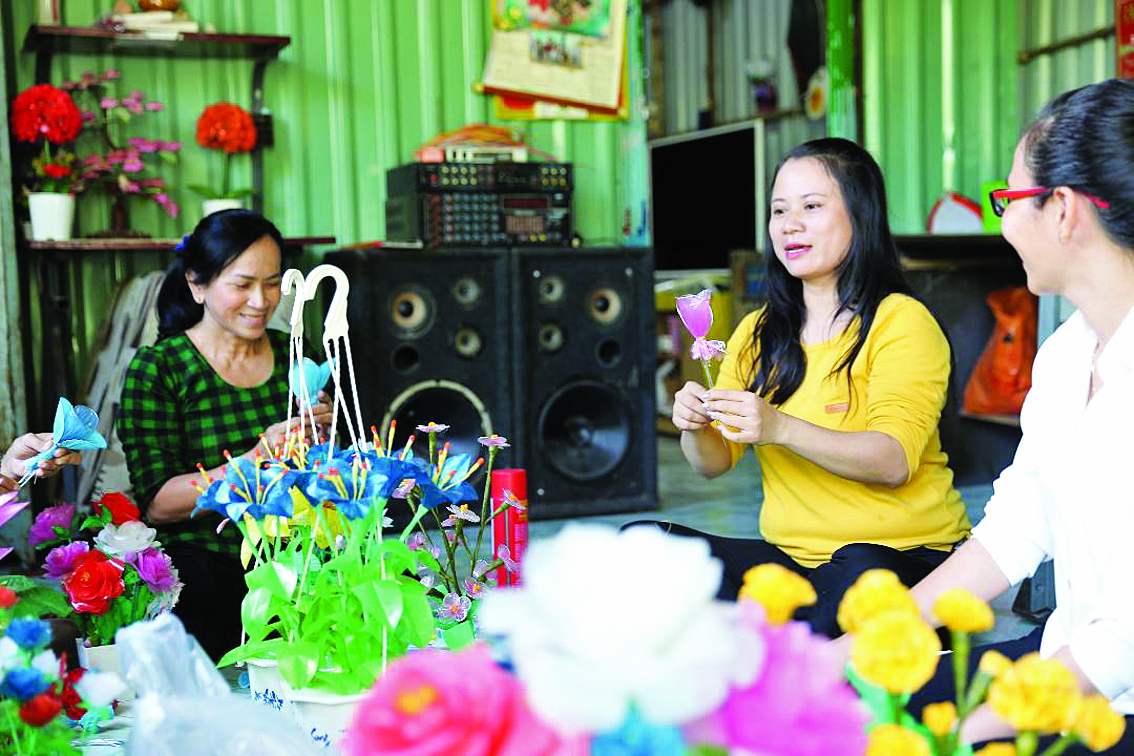 Làm hoa từ rác Chị Nguyễn Thị Nhuyễn (giữa) đang giới thiệu cách làm hoa ni-lông cho chị em phụ nữ các ấp của xã Bình Khánh