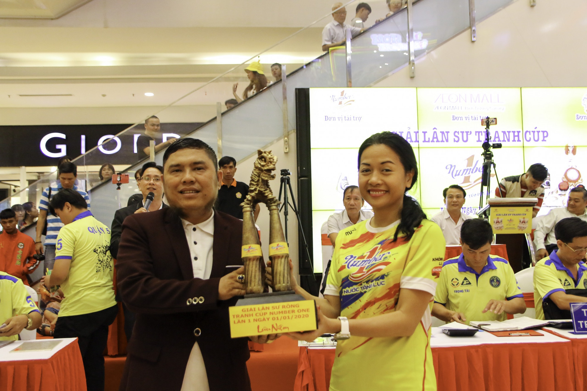 Mãn nhãn với màn tranh tài của 30 đội tại Giải lân sư tranh Cup Number 1 Bà Trần Uyên Phương - Phó tổng giám đốc Tập đoàn Tân Hiệp Phát trao chiếc cup Number 1 cho đại diện BTC. Chiếc cup mô phỏng con lân đứng trên mai hoa thung là 4 chai Nước tăng lực Number 1