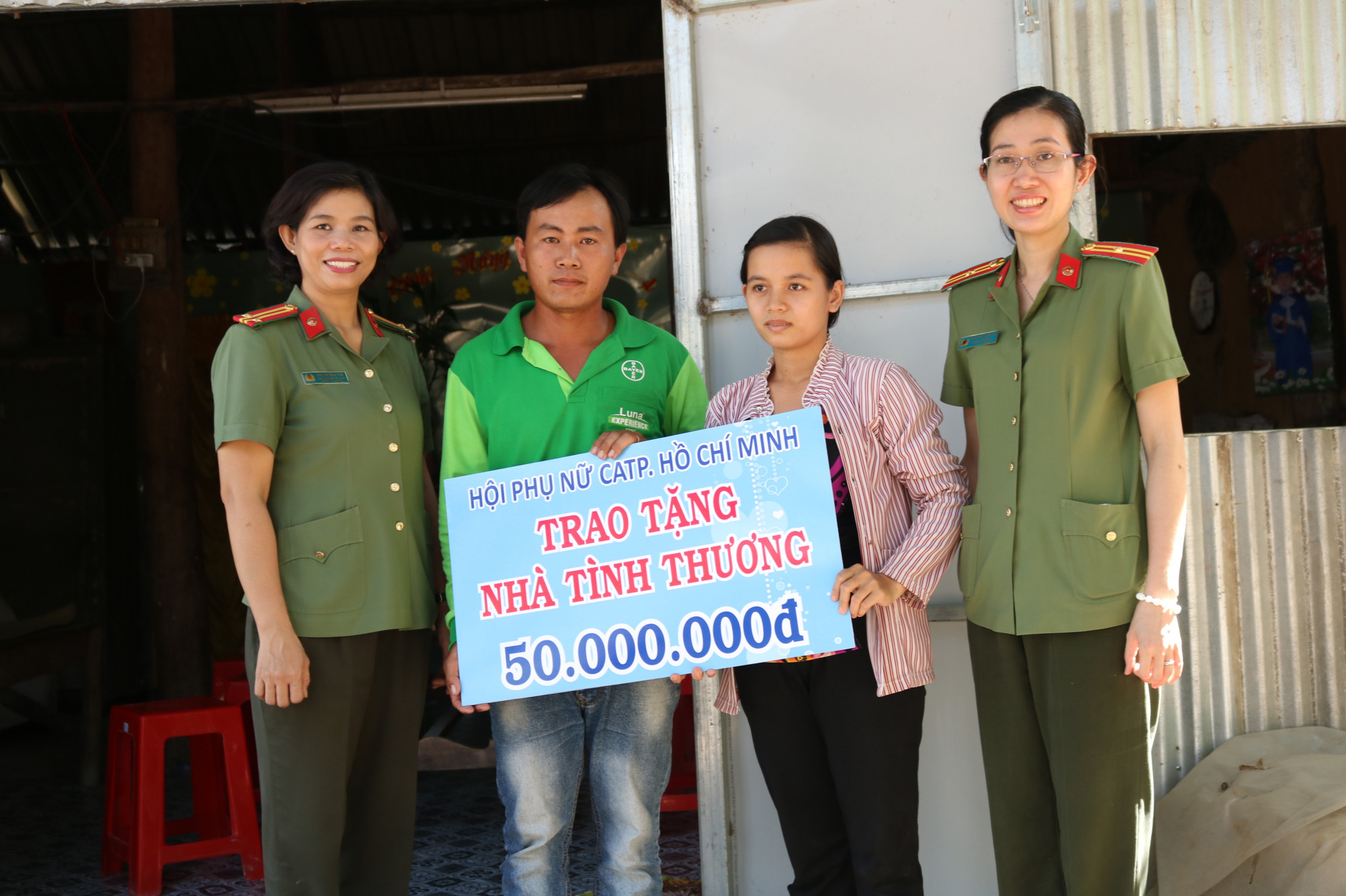 Mang Tết đến với vùng biên Vợ chồng anh Huy nhận bảng tượng trưng kinh phí do Hội Phụ nữ Công an TP.HCM hỗ trợ để xây nhà.