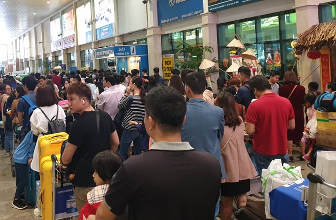 Sân bay Tân Sơn Nhất chen chúc người chờ về quê ngày 24 Tết Hành khách xếp hàng rồng rắn để chờ làm thủ tục