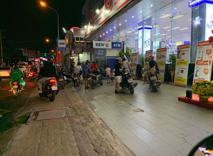 Nhiều cây ATM 'thất thủ', khách nhờ dịch vụ rút hộ Khách xếp hàng chờ rút tiền trước siêu thị điện máy Nguyên Kim Thủ Đức
