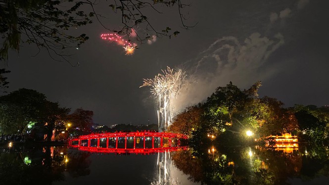 Người Sài Gòn đeo khẩu trang đón giao thừa, Hà Nội chào năm mới sau cơn mưa Tuy nhiên, vào khoảnh khắc đón chào năm mới, trời Hà Nội đã tạnh ráo, giúp người dân Thủ Đô xem được trọn vẹn màn bắn pháo hoa mừng Xuân - Ảnh: Hồng Vĩnh