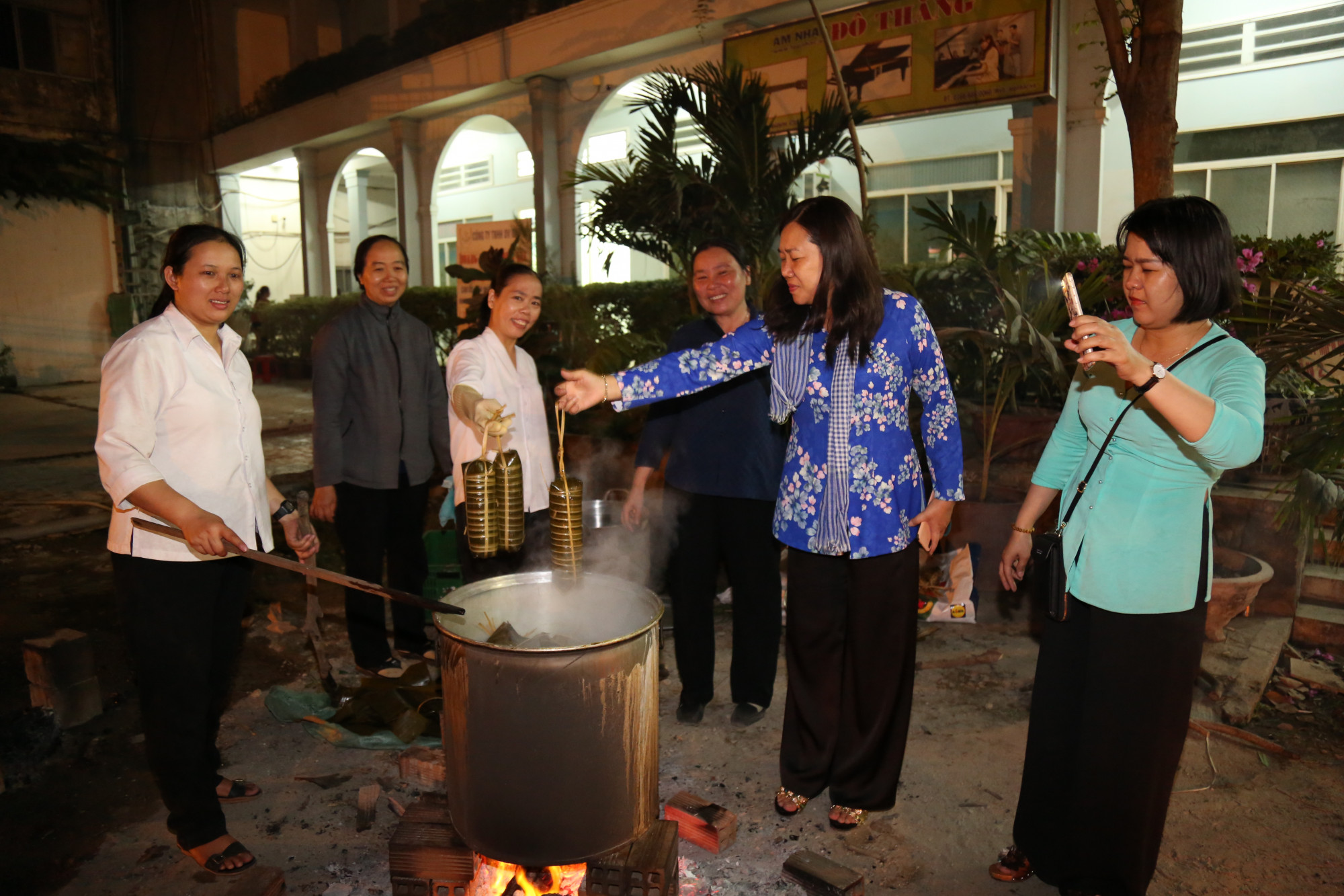 Tết ấm cho mọi nhà Bà Nguyễn Thị Tuyết Nga (thứ 2, từ phải qua) - Chủ tịch Hội LHPN quận 2 - cùng các sơ canh lửa, vớt bánh tét.