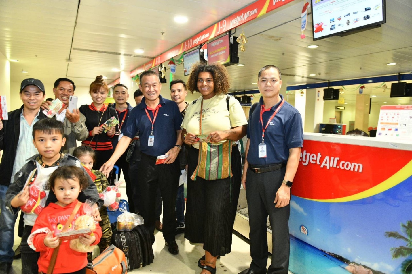 Lãnh đạo Vietjet tặng quà những hành khách đầu tiên của năm mới Những hành khách tất bật làm thủ tục cho chuyến bay trở về đón tết đoàn viên cùng gia đình bất ngờ nhận quà lì xì của giám đốc điều hành Lưu Đức Khánh. Ảnh Vietjet
