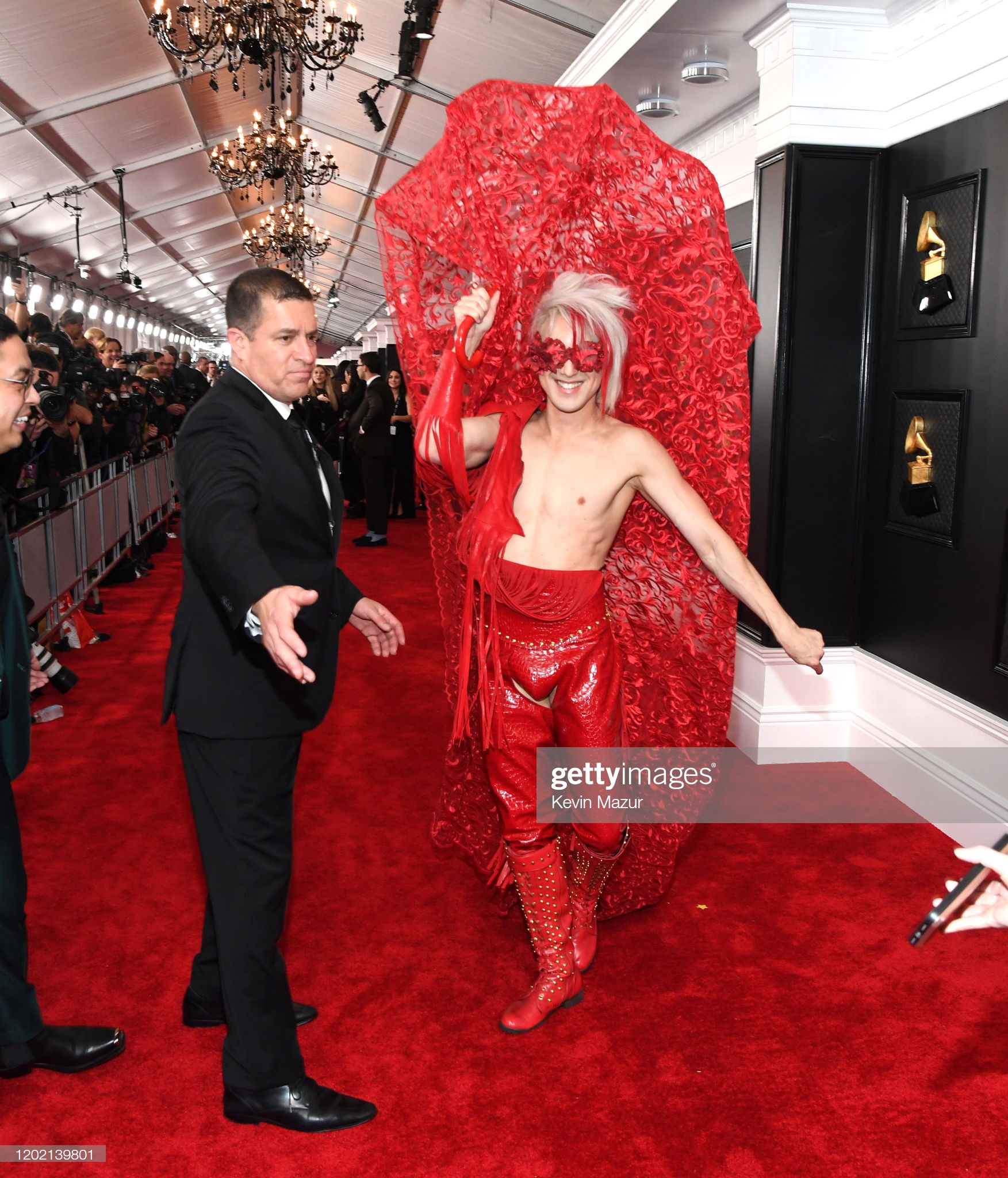 Thảm đỏ Grammy 2020: Thông điệp chính trị, trò lố và những bộ cánh đẹp Ricky Rebel sau phần tạo dáng, không rõ cố tình hay trang phục gặp sự cố mà nửa thân áo trên của anh bị rơi ra.