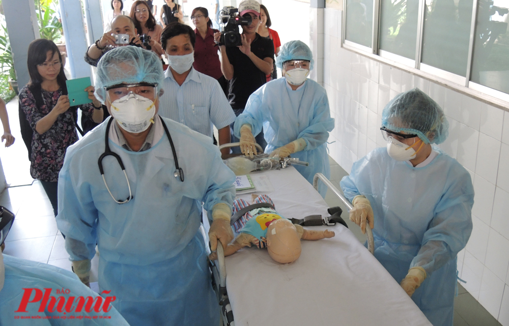 TPHCM kiểm soát khả năng lây lan virus corona như thế nào? Vận chuyển một bệnh nhi nghi nhiễm Mers-CoV trong tình huống giả định tại BV Nhi đồng 1. Bệnh nhi sẽ được đưa vào phòng cách ly theo một con đường riêng, ít người qua lại