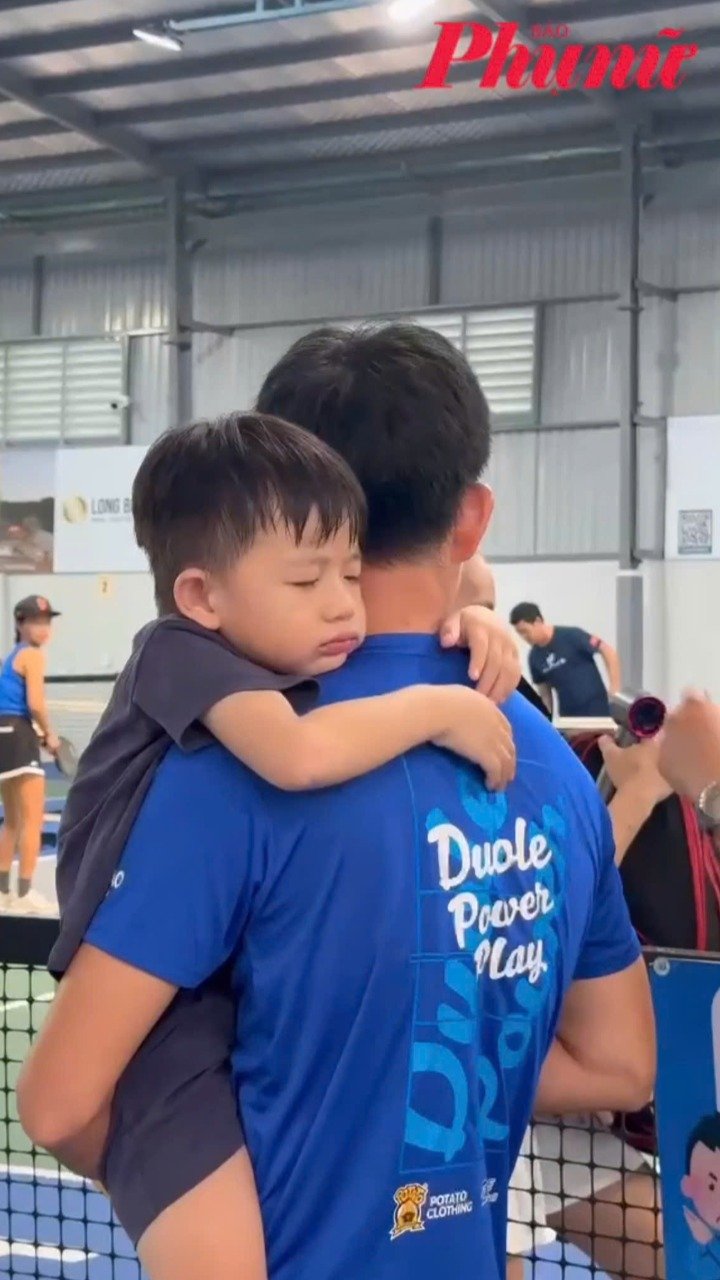 Em bé ngủ ngoan trong vòng tay cha giữa giải Pickleball