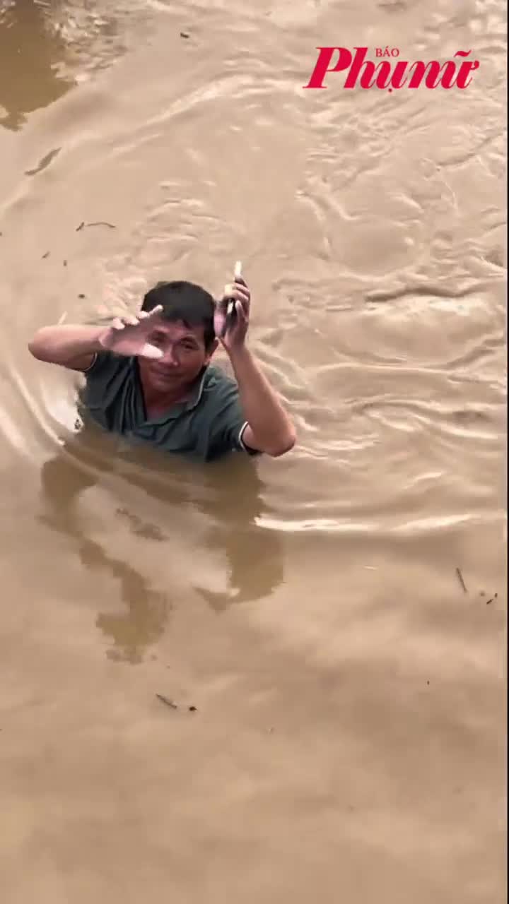 Người dân bì bõm giữa dòng nước lũ ngập đến gần cổ