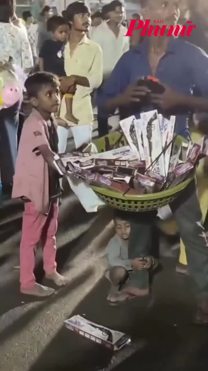 Đứa con ngủ gục dưới chân người cha bán hàng rong