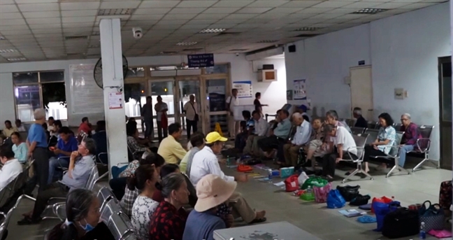 Xếp hàng từ 3 giờ sáng, người bệnh đặt chai nước, túi xách... để giữ chỗ khám bệnh Xep hang tu 3 gio sang, nguoi benh dat chai nuoc, tui xach... de giu cho kham benh