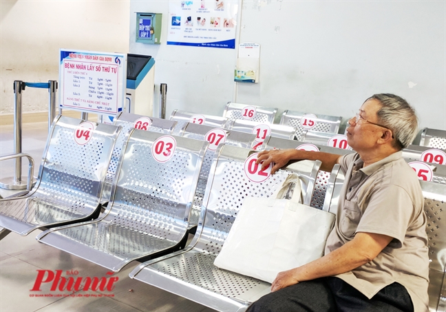 Xếp hàng từ 3 giờ sáng, người bệnh đặt chai nước, túi xách... để giữ chỗ khám bệnh Xep hang tu 3 gio sang, nguoi benh dat chai nuoc, tui xach... de giu cho kham benh